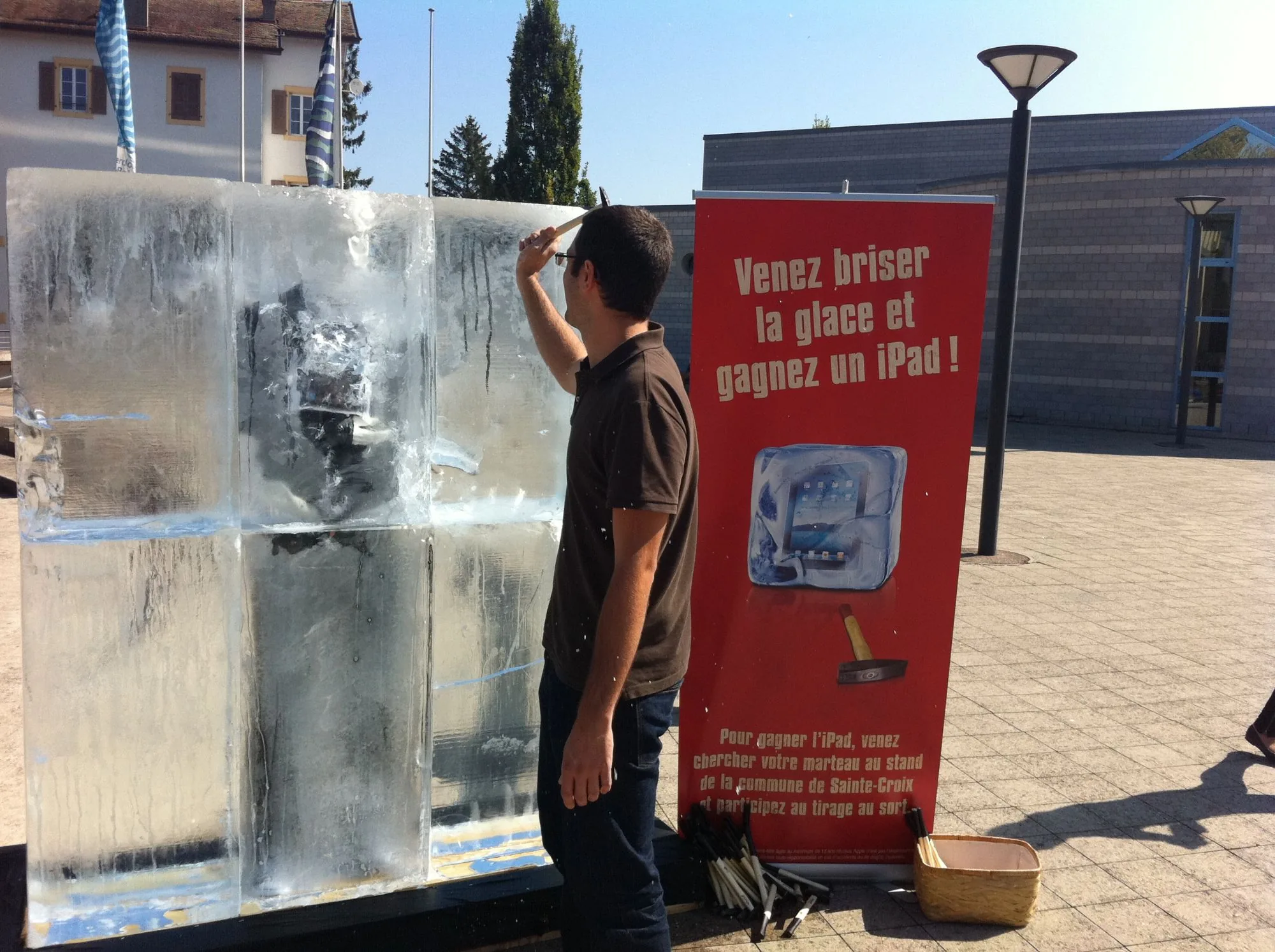 Visiteurs réunis autour du bloc de glace et des roll-ups de Sainte-Croix