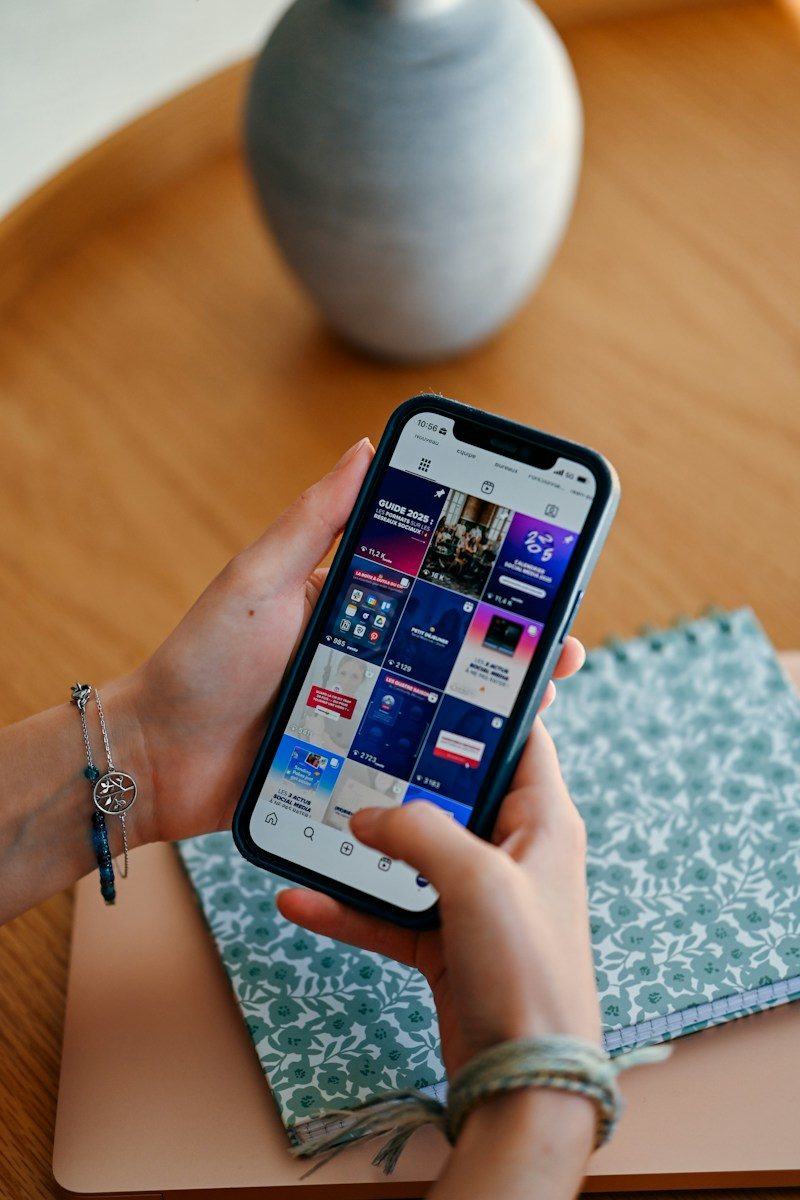 Smartphone tenu en main, l’écran affichant des applications
